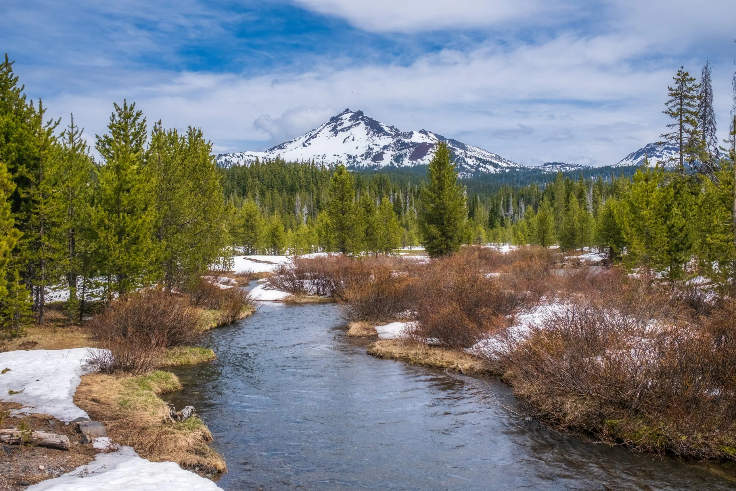 Mesmerizing shot of a beautiful snowy rocky park around the lake with a background of a mountain A mesmerizing shot of a beautiful snowy rocky park around the lake with a background of a mountain
